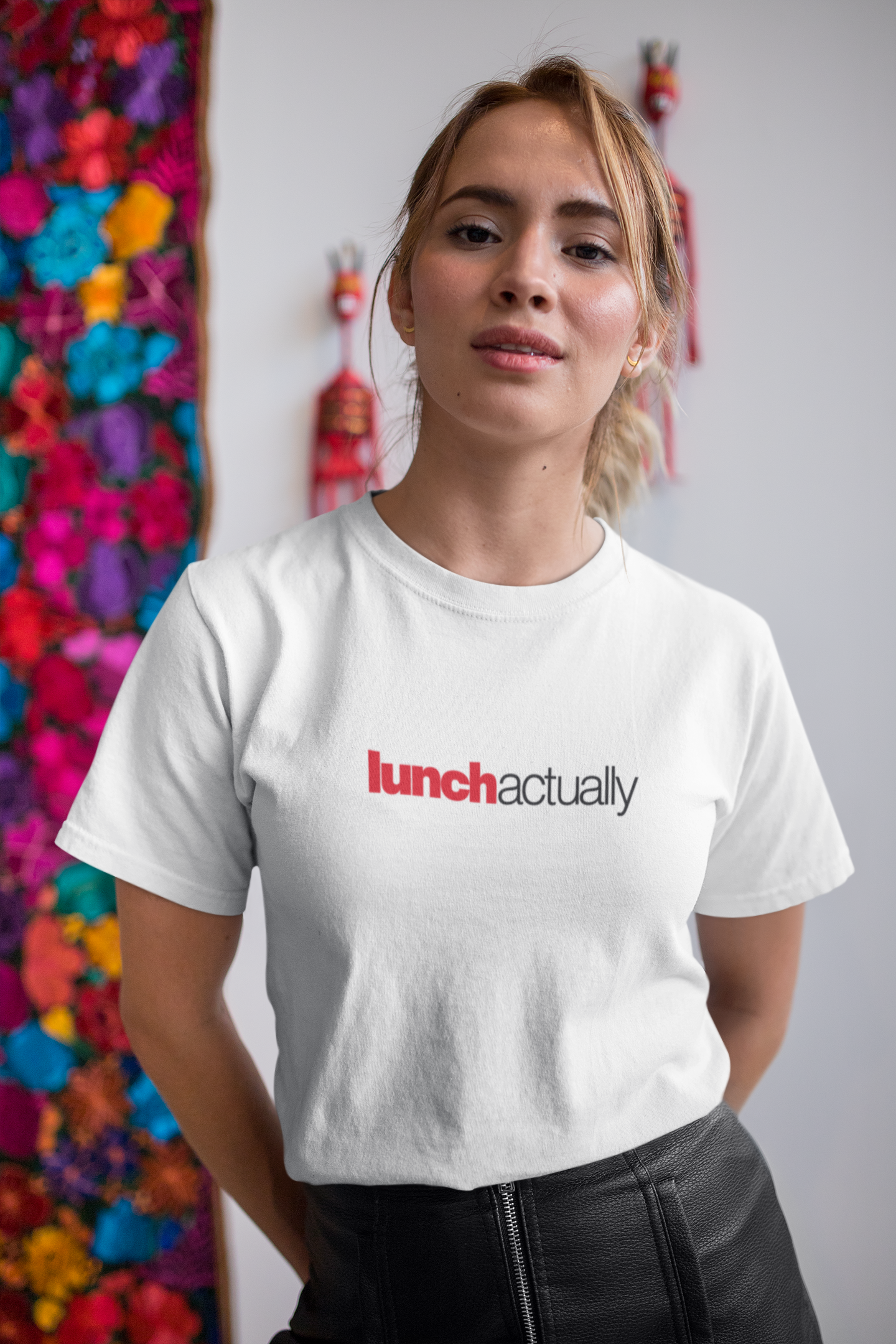 Person wearing a white t-shirt with 'lunch actually' text in a colorful room.
